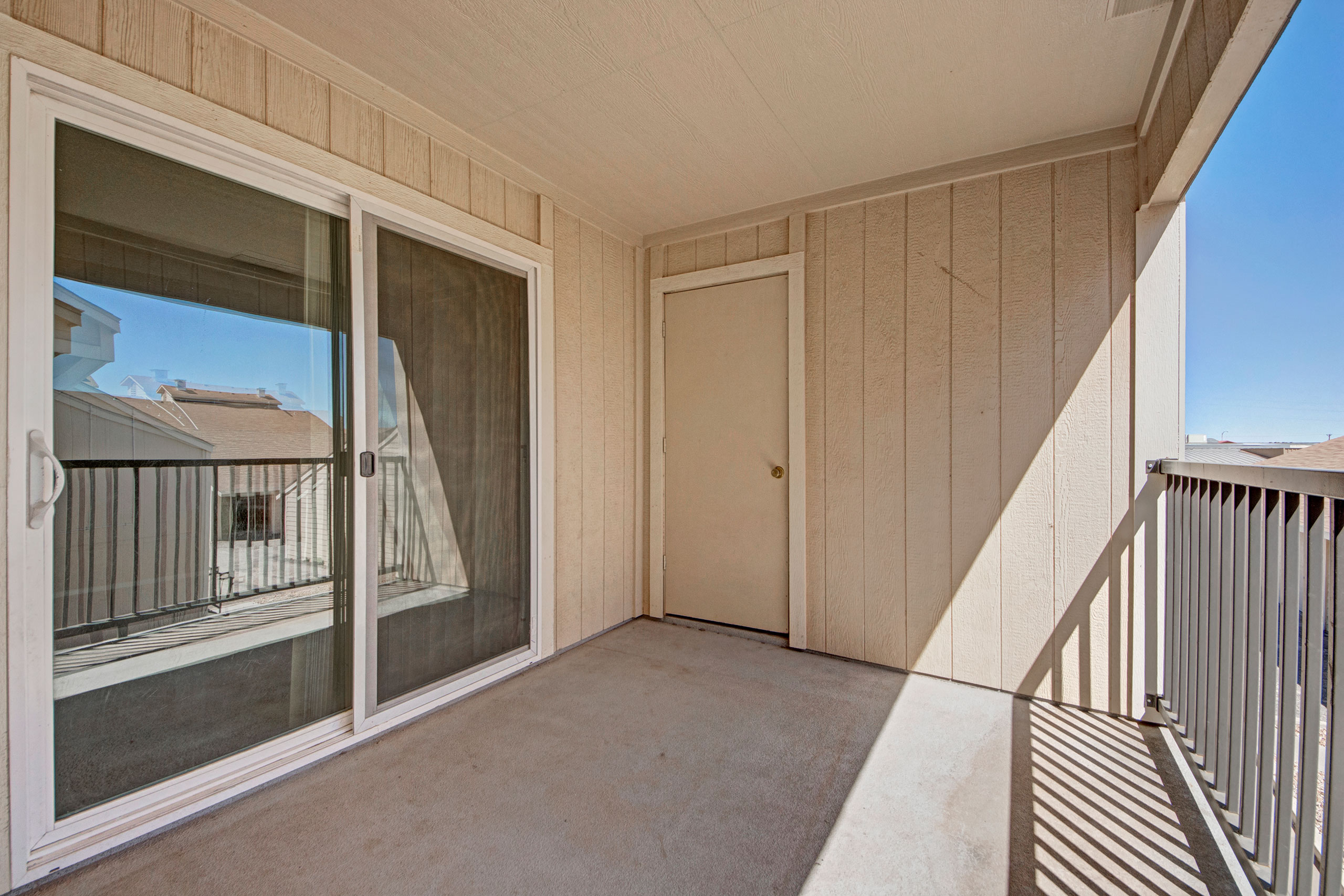 A large balcony with additional storage and a sliding glass door leading to the living room
