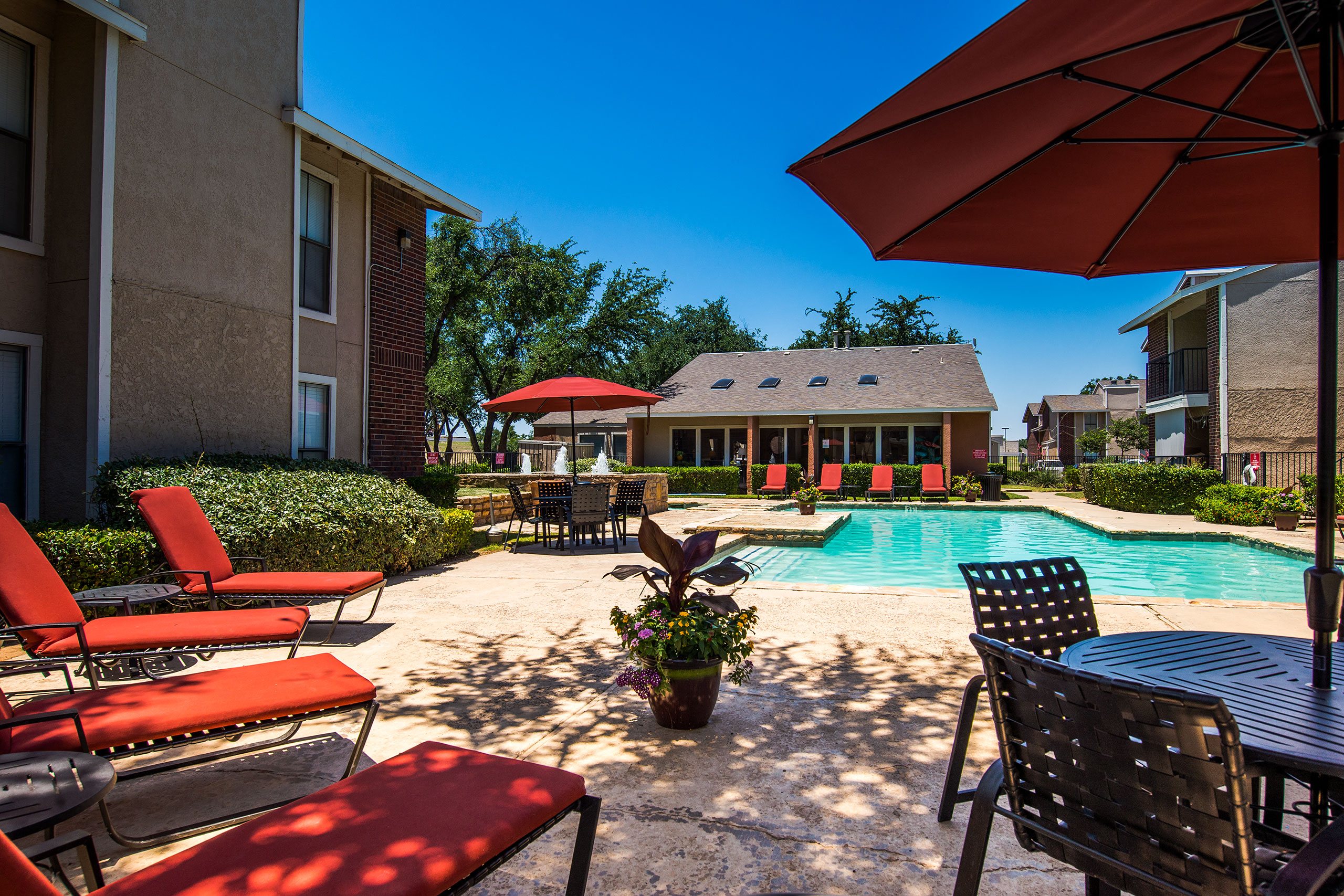 An outdoor pool surrounded by lounge chairs for resident use