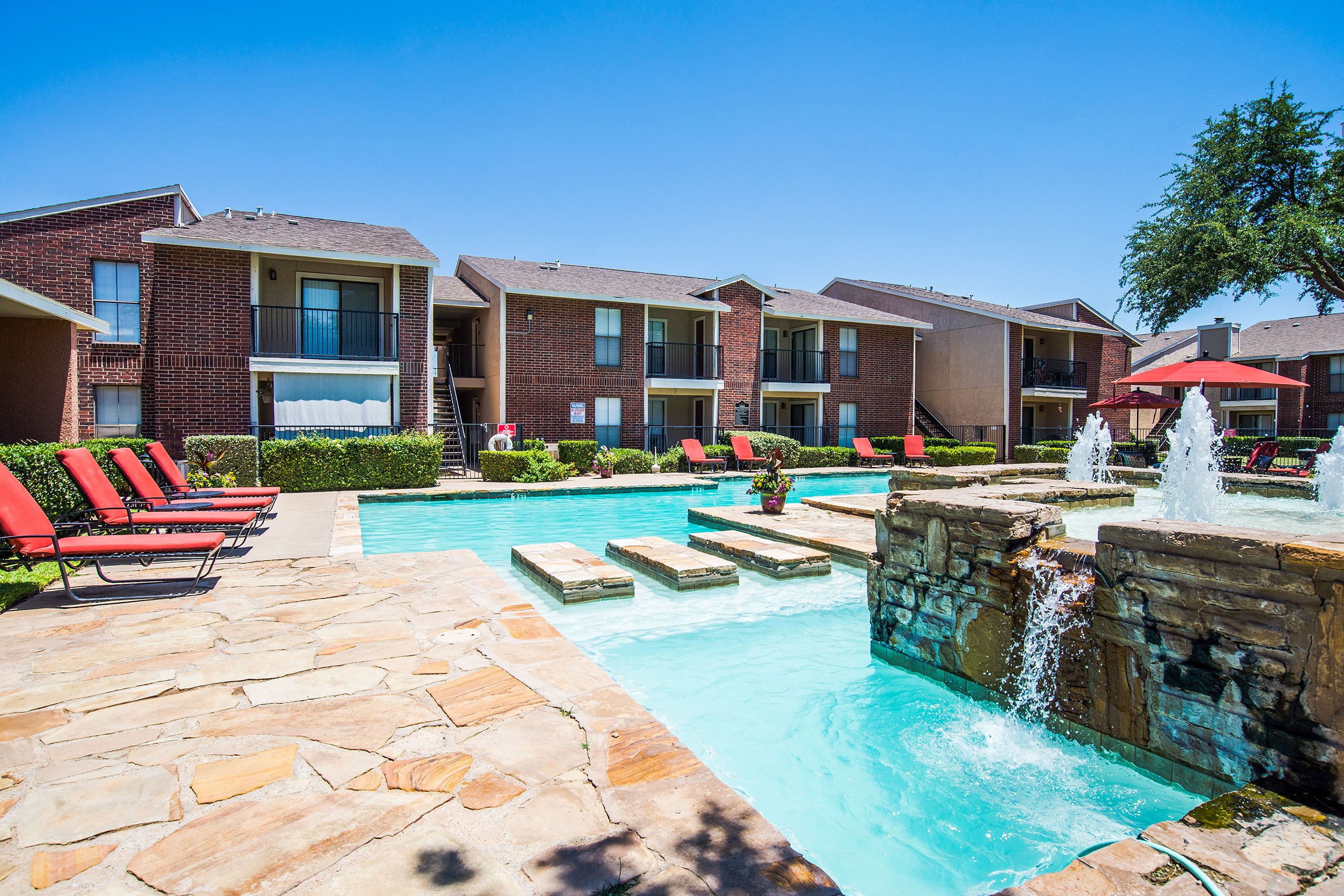 An outdoor pool surrounded by lounge chairs for resident use