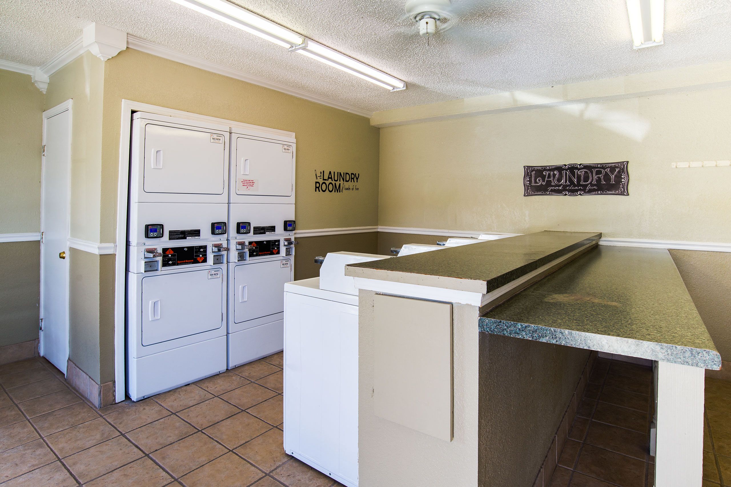 A shared laundry room with multiple washers and dryers