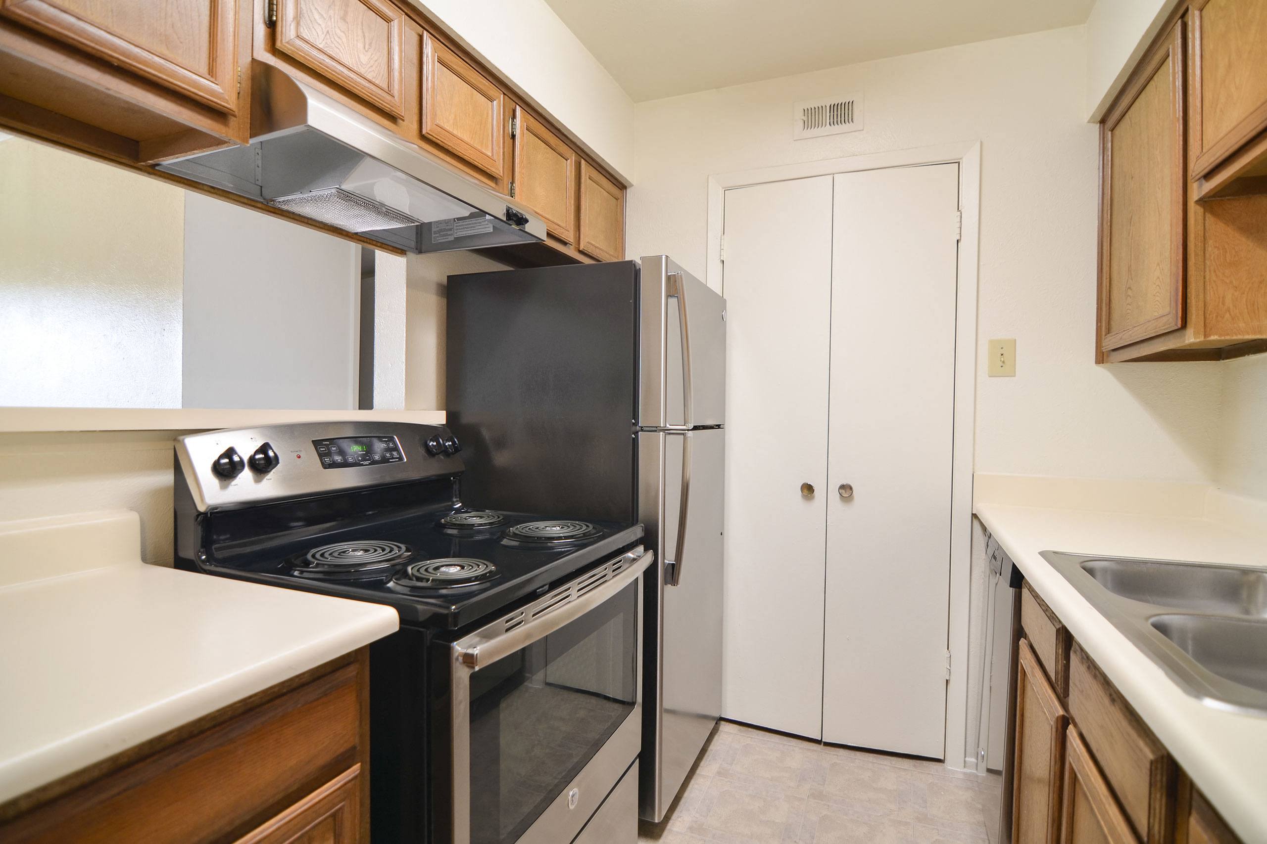 A kitchen with stainless steel appliances and full size washer dryer connections