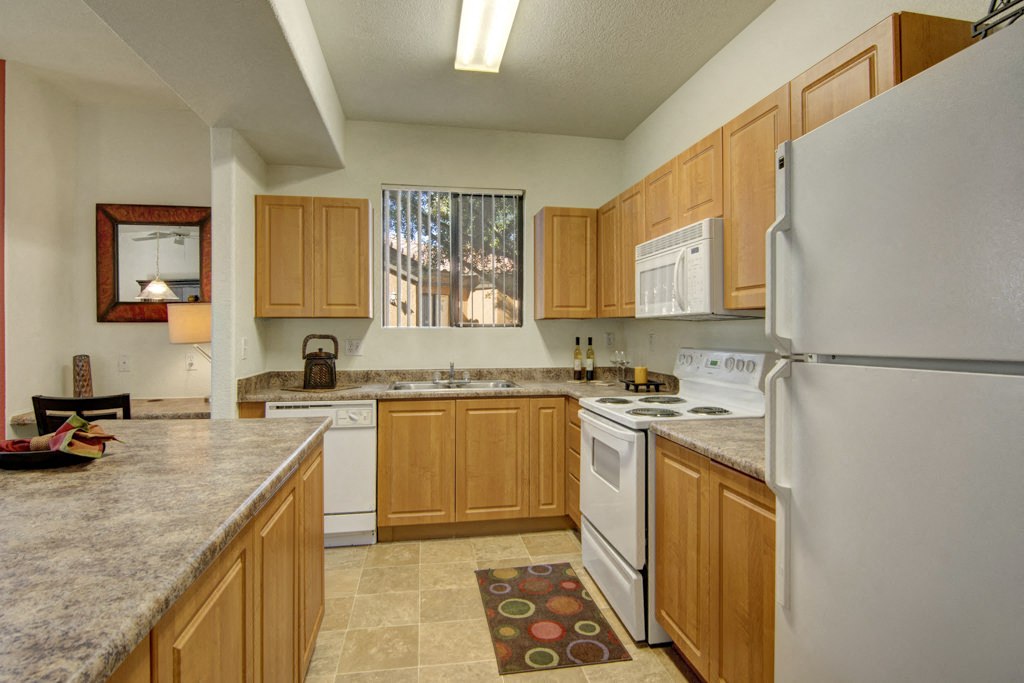 Arezzo Apartments- kitchen with white appliances and wooden cabinets