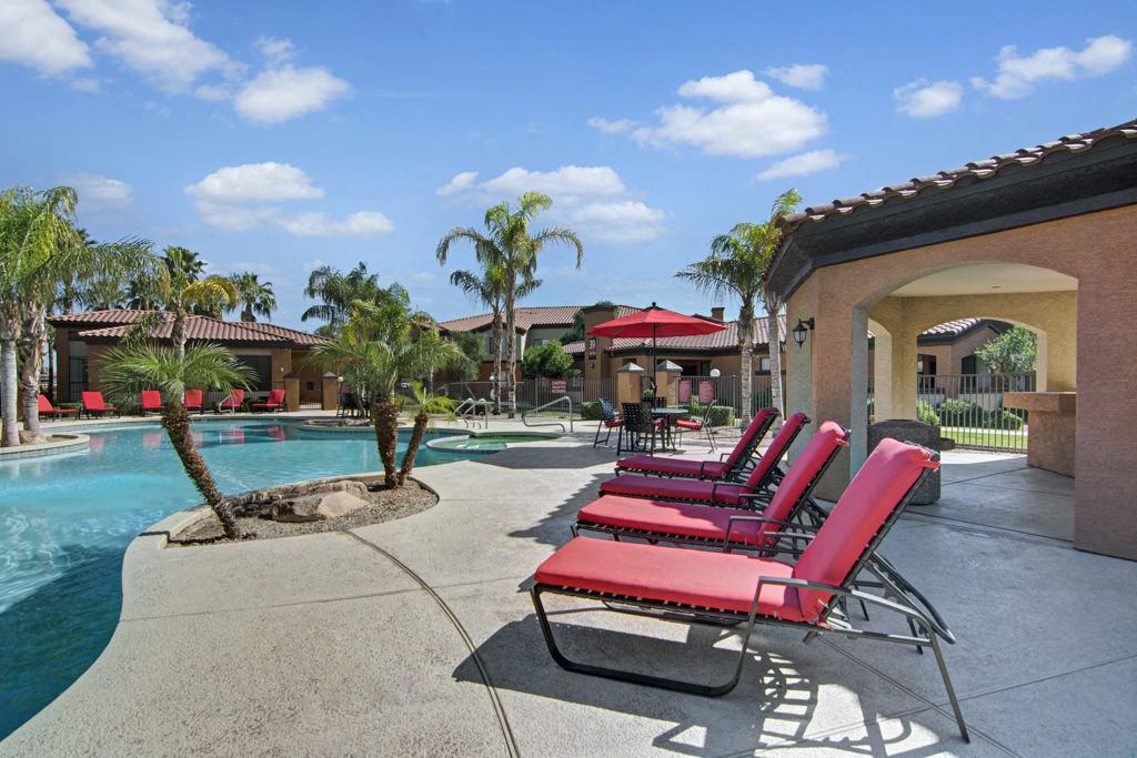 Arezzo Apartments- pool with red chaise lounges and palm trees