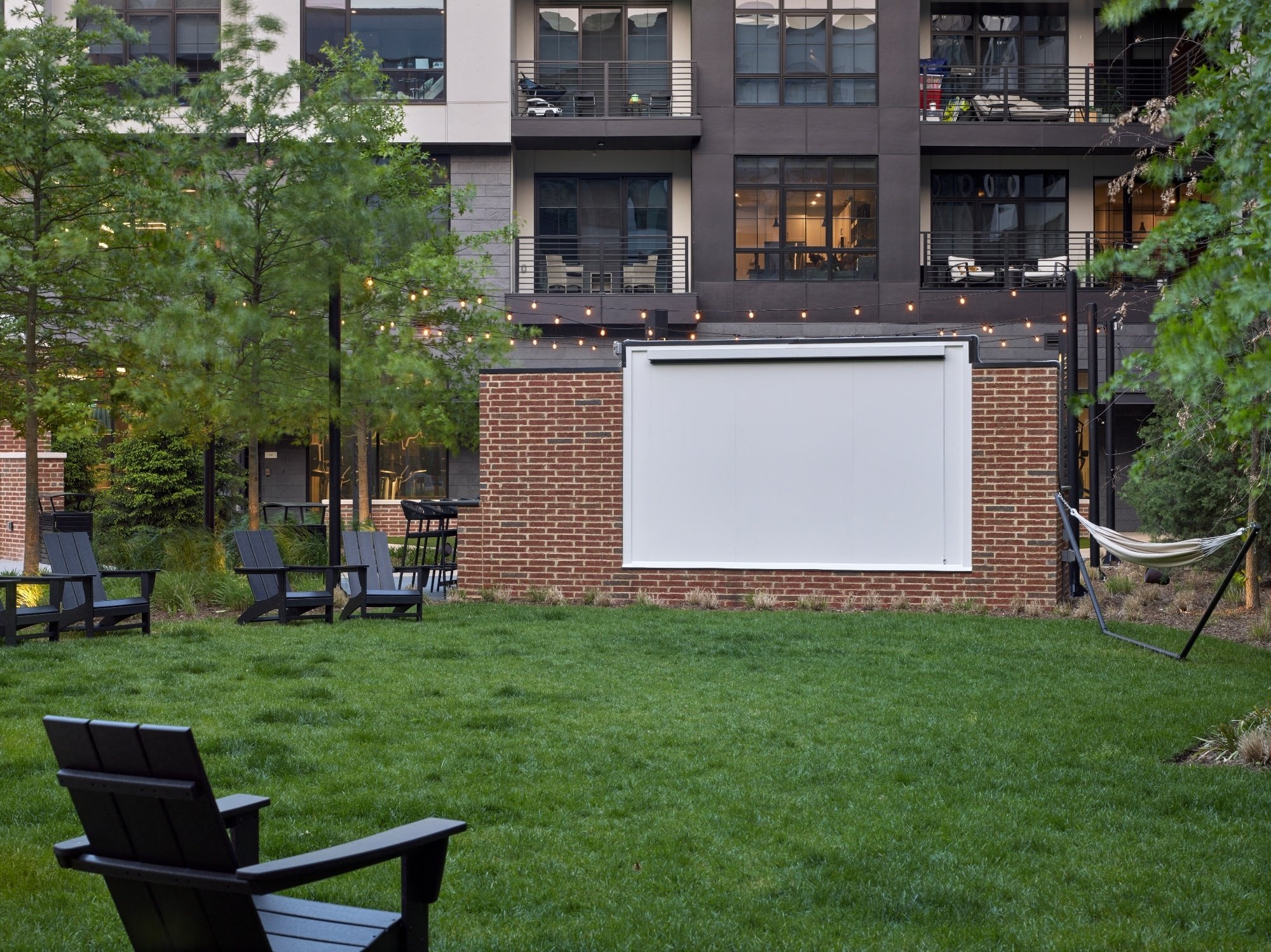 outdoor seating, outdoor tv, movie screen, grass, turf, landscaping, courtyard, outdoor lounge, chairs, lounge chairs