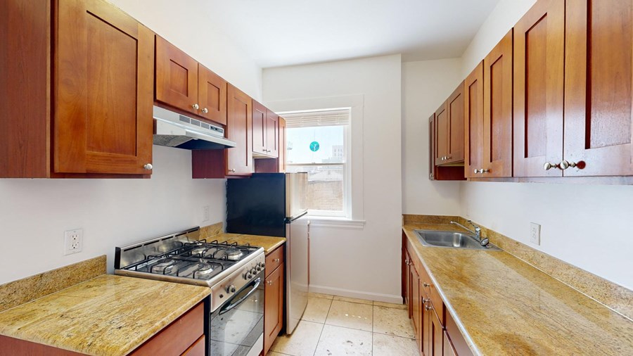 a kitchen with wooden cabinets and a stove and a sink