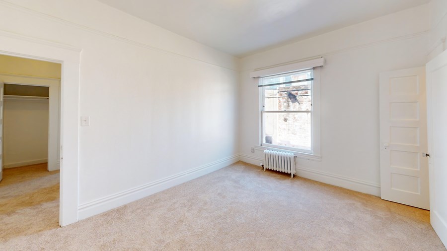 A room with white walls and a window with a white frame.