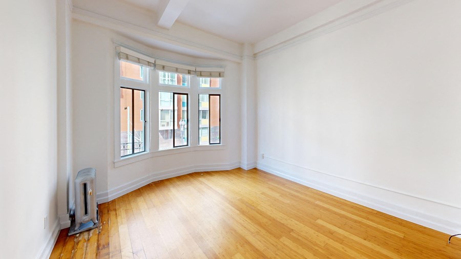 a living room with white walls and wood floors and a fireplace