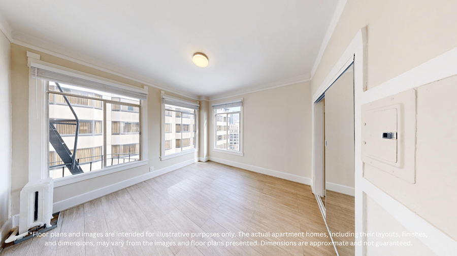 A spacious room with a staircase and large windows.