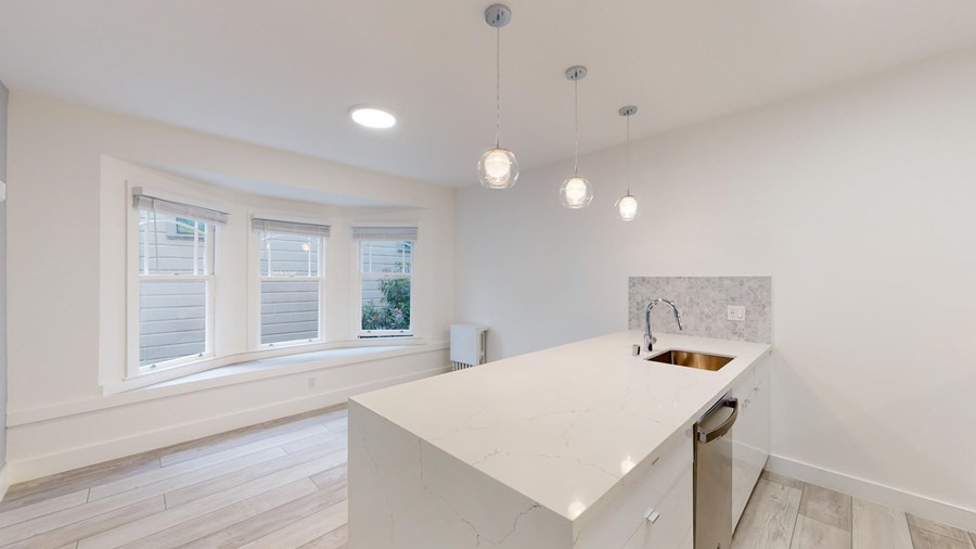 A kitchen with white cabinets and a white countertop.