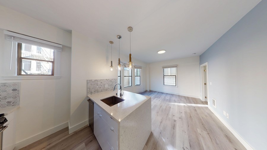 A kitchen with a white countertop and a sink.
