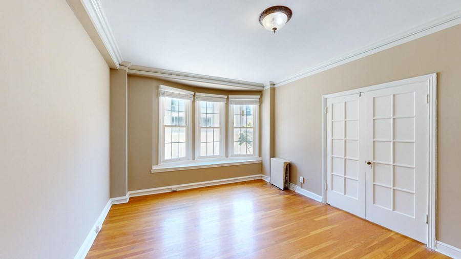 A room with a white door and a window with blinds.