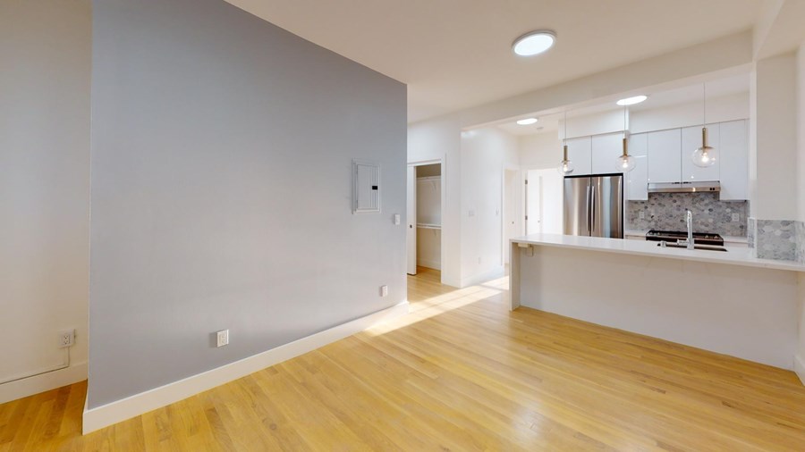 A kitchen area with a refrigerator, oven, and sink.