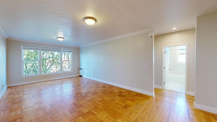 A room with wooden flooring and a window.