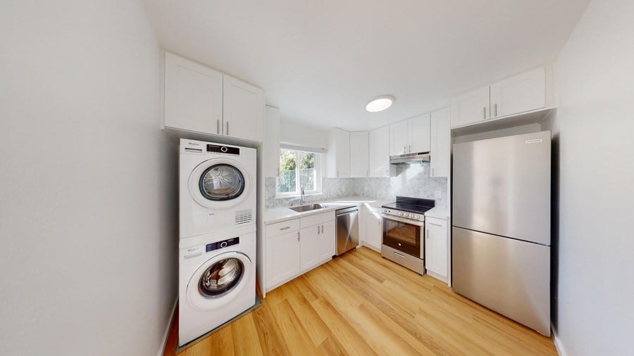 A modern kitchen with a washing machine and a refrigerator.