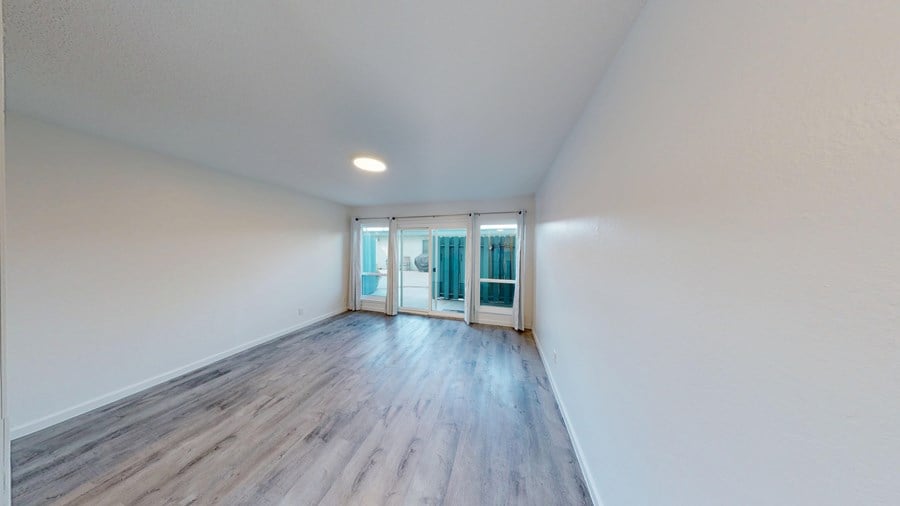 A room with wooden flooring and a window with glass doors.