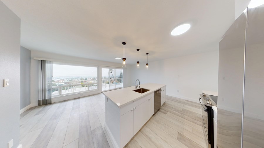 A modern kitchen with a large island and a view of the city.