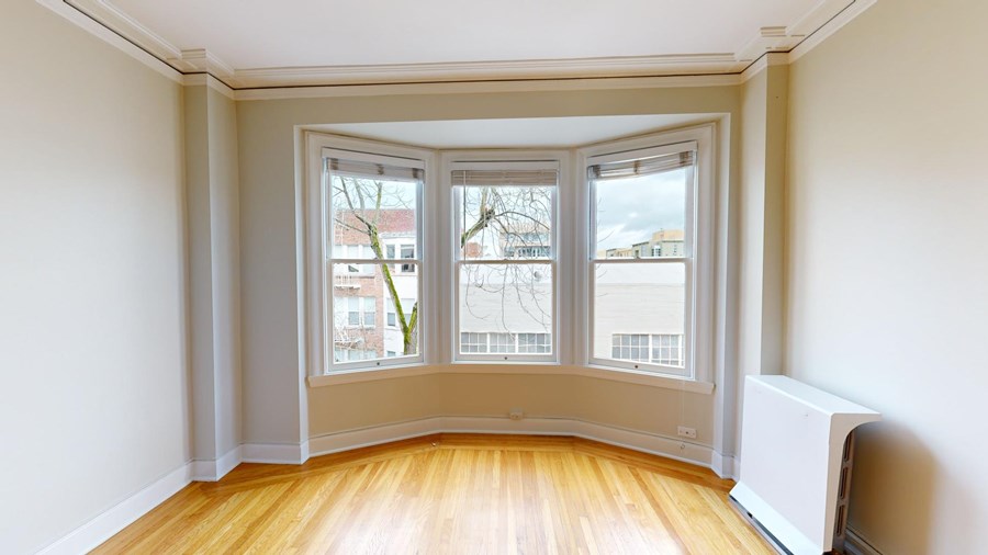 A room with a large window and a radiator on the wall.