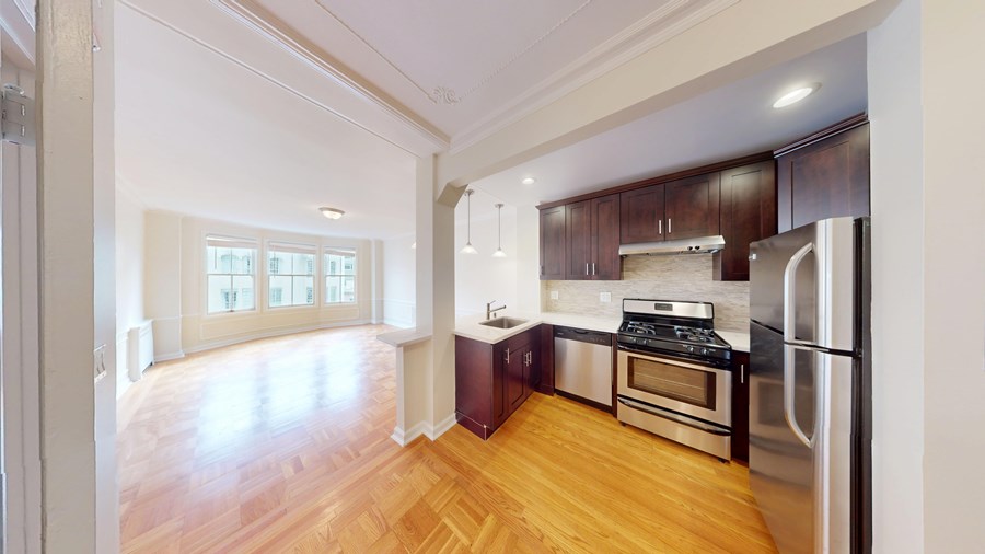 A kitchen with wooden floors and stainless steel appliances.