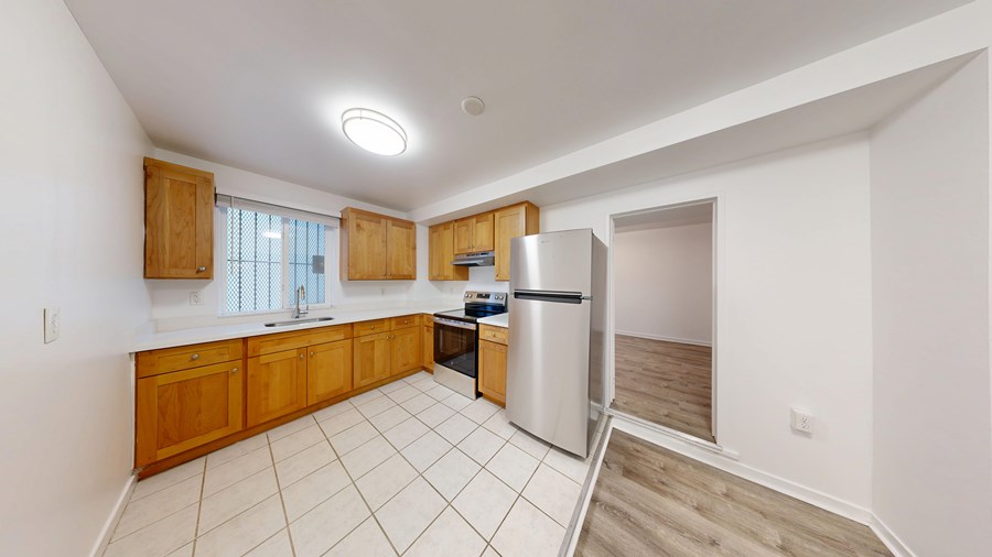 A kitchen with wooden cabinets and a white refrigerator.