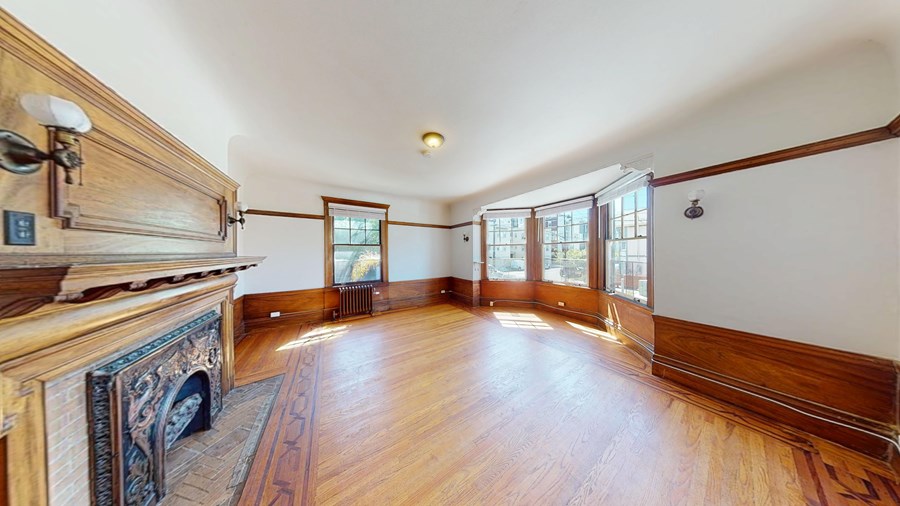 A large room with wood floors and a fireplace.