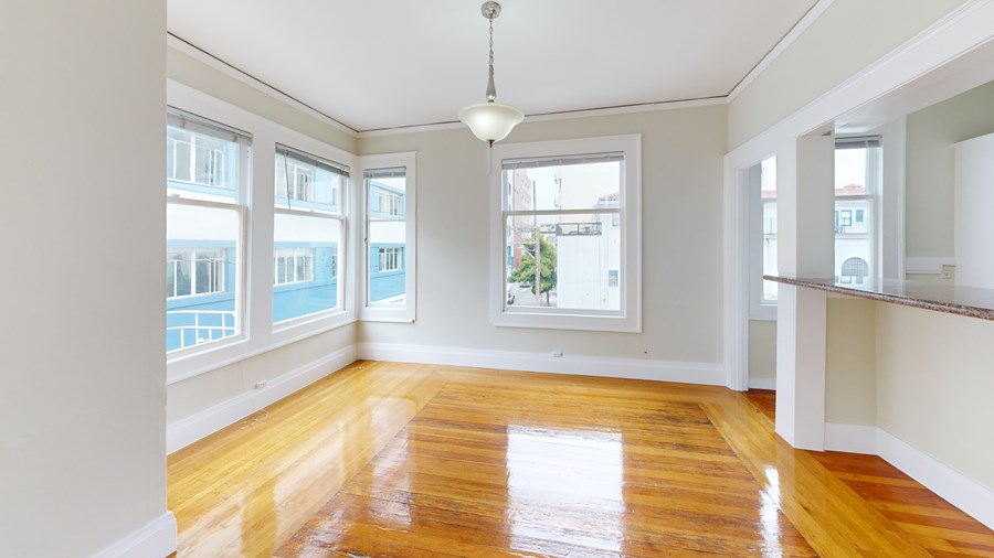 A room with wooden floors and a large window.