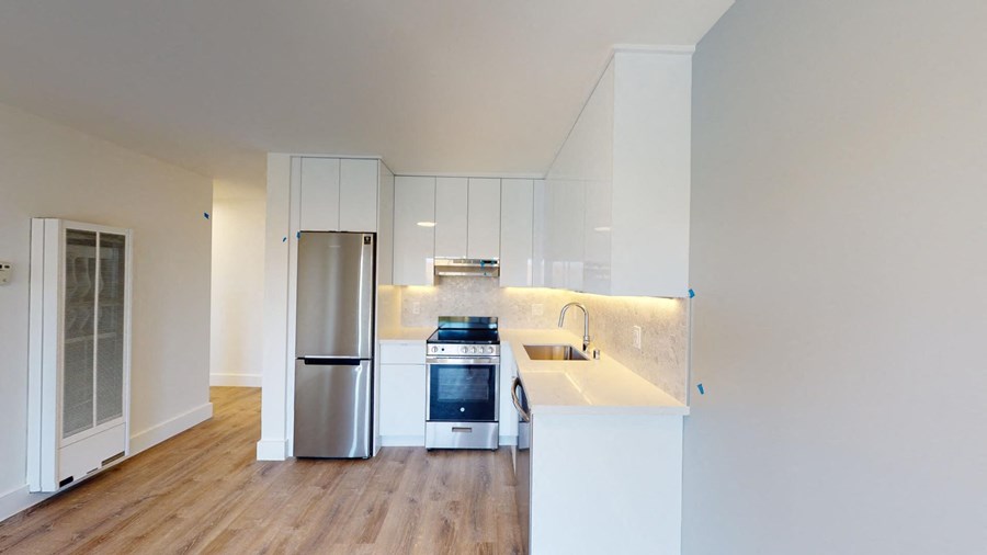 a kitchen with white cabinets and a stainless steel refrigerator