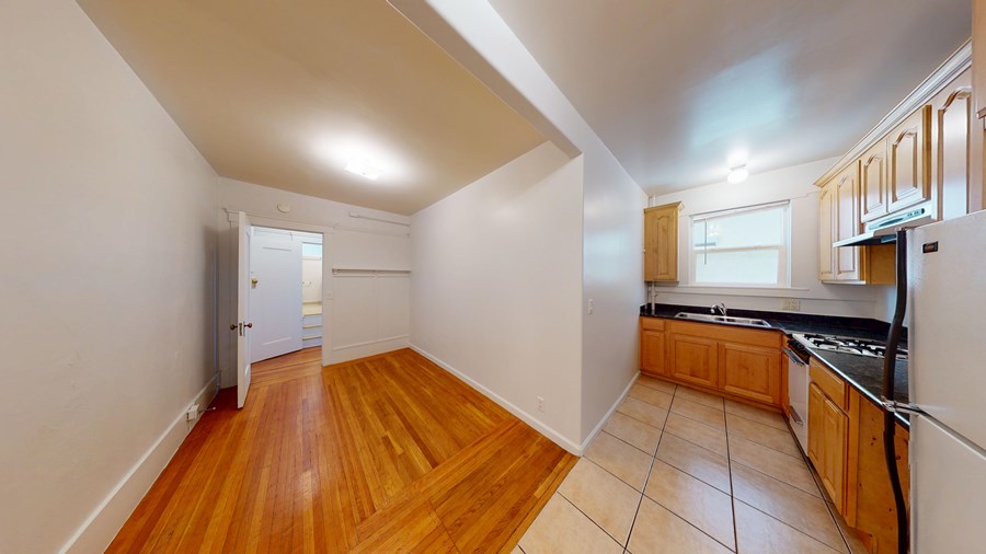 A kitchen with wooden floors and white walls.