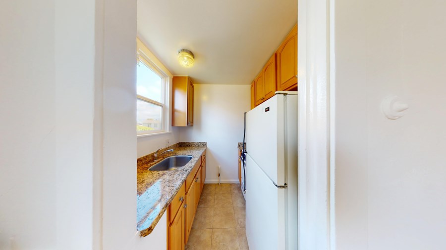A kitchen with a sink and refrigerator.