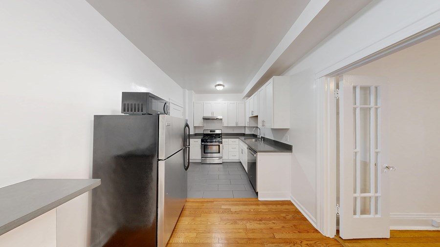 A kitchen with a refrigerator, stove, and oven.