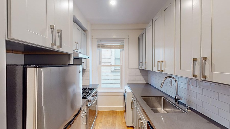 a kitchen with stainless steel appliances and white cabinets