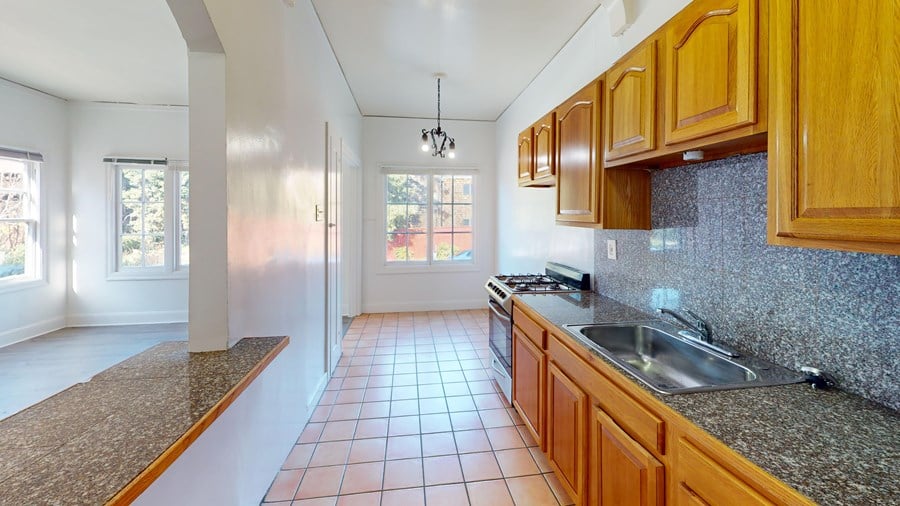 A kitchen with wooden cabinets and a granite countertop.