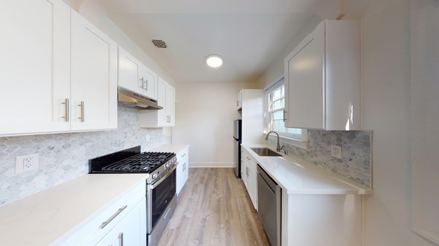 A kitchen with white cabinets and a black stove top.
