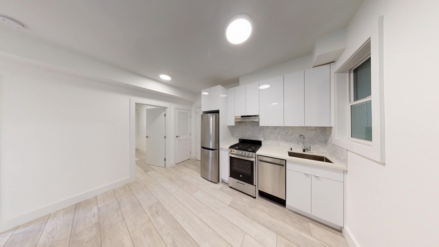 A modern kitchen with white cabinets and stainless steel appliances.