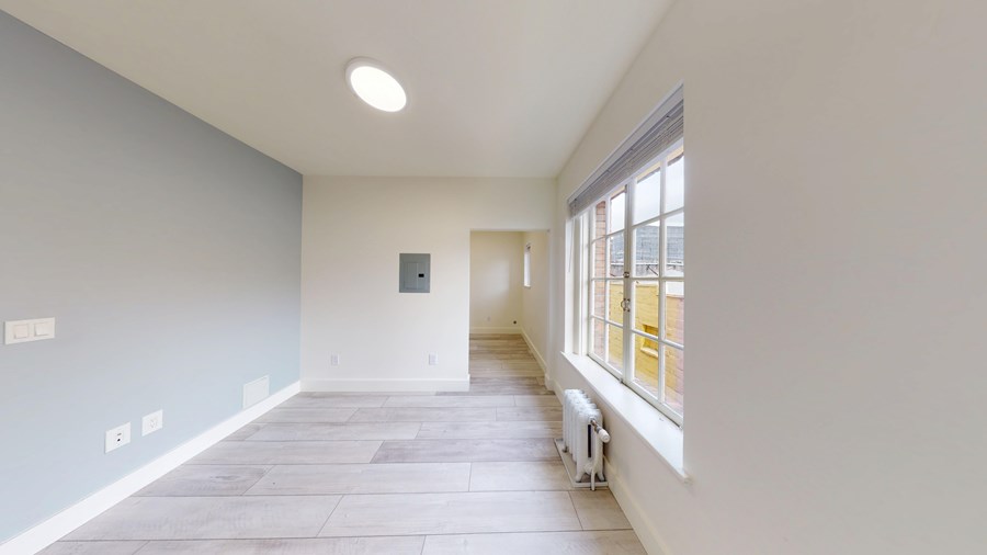 A room with a window and a radiator on the floor.