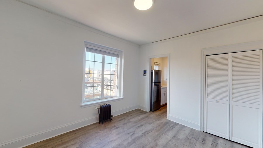 A room with a window and a radiator on the floor.