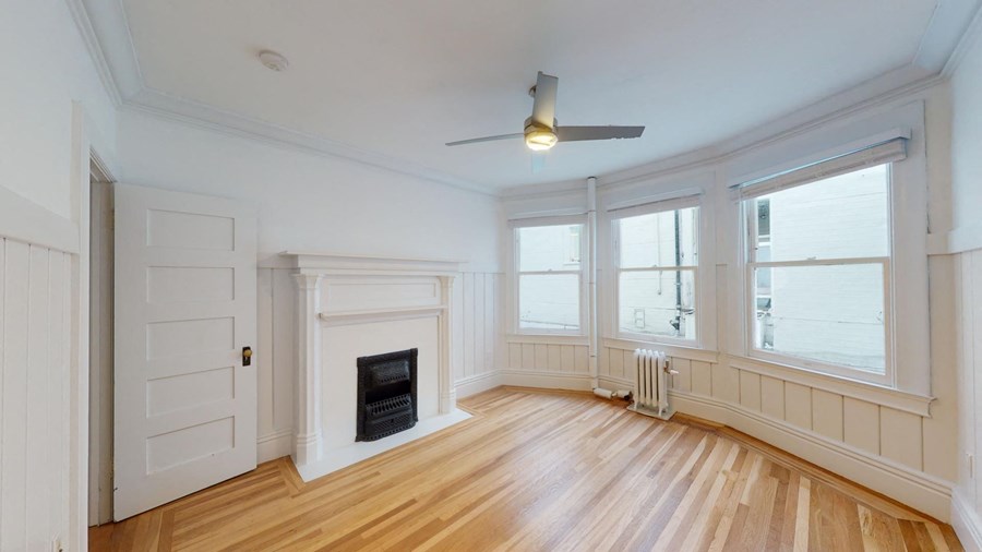 A room with a fireplace and a ceiling fan.