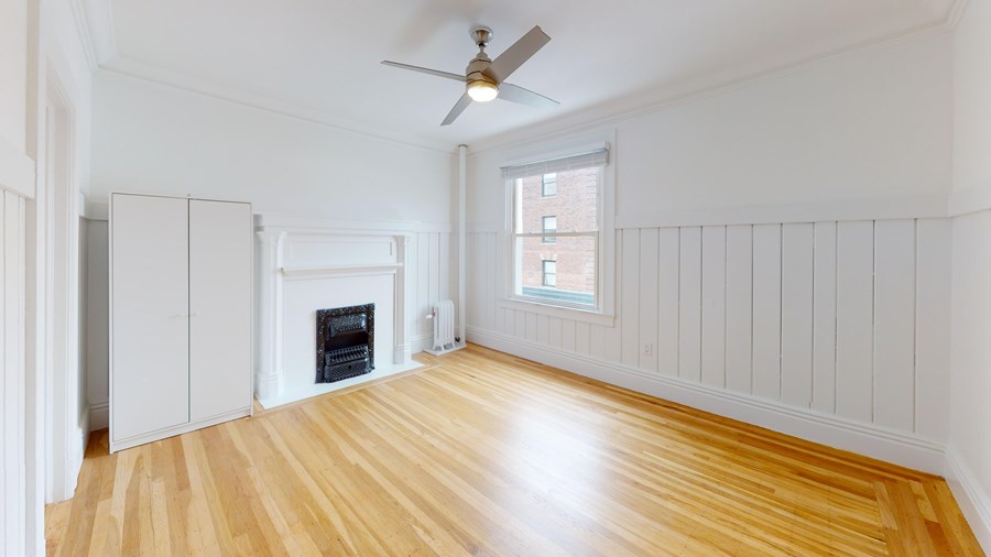 A room with a fireplace and a ceiling fan.