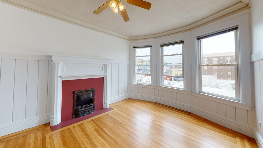 A room with a fireplace and a ceiling fan.