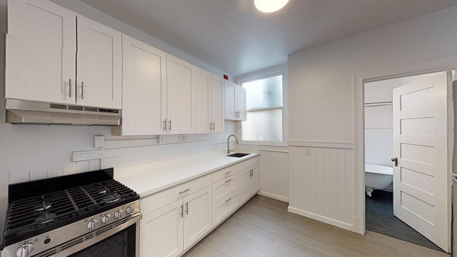 A kitchen with white cabinets and a black stove top.