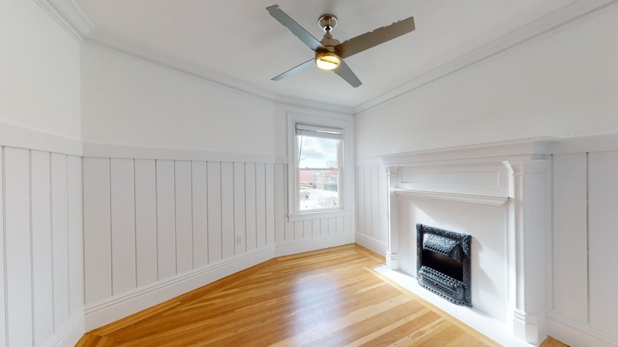 A room with a fireplace and a ceiling fan.