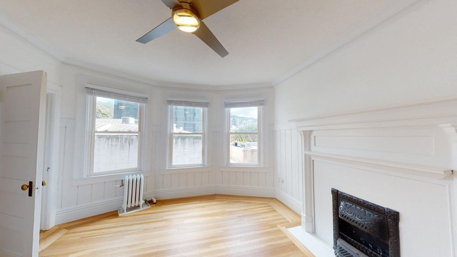 a living room with a fireplace and a ceiling fan