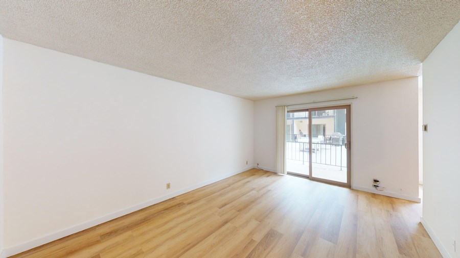 A room with wooden floors and a sliding glass door.