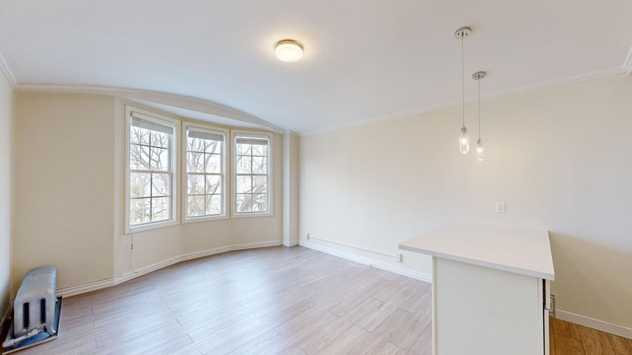 A room with a white cabinet and a window with a view of trees.