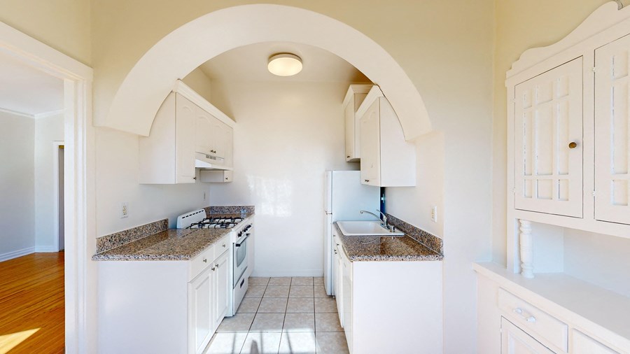 a kitchen with white cabinets and granite counter tops