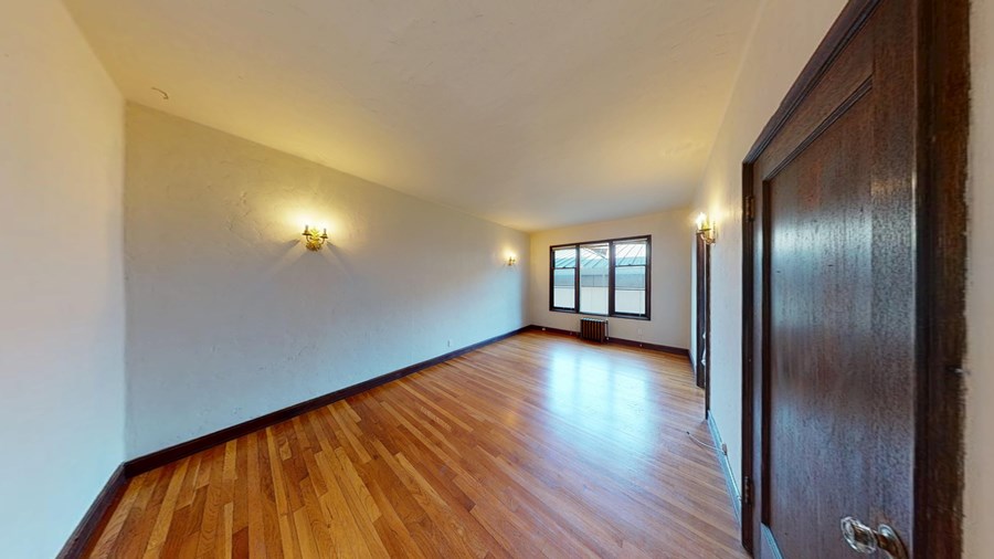 A room with wooden floors and a door on the right.