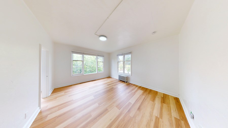 A room with wooden flooring and white walls.