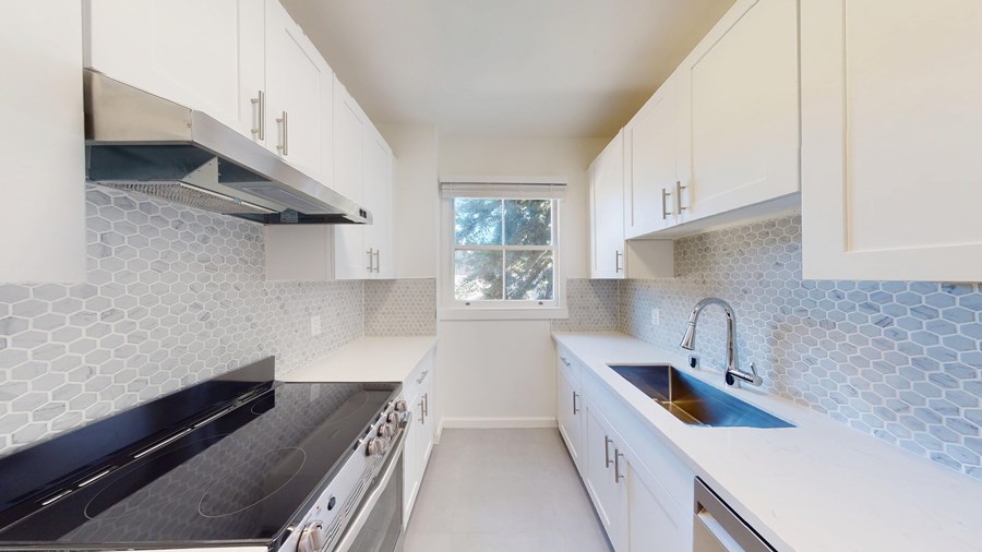 A kitchen with white cabinets and a black stove top oven.