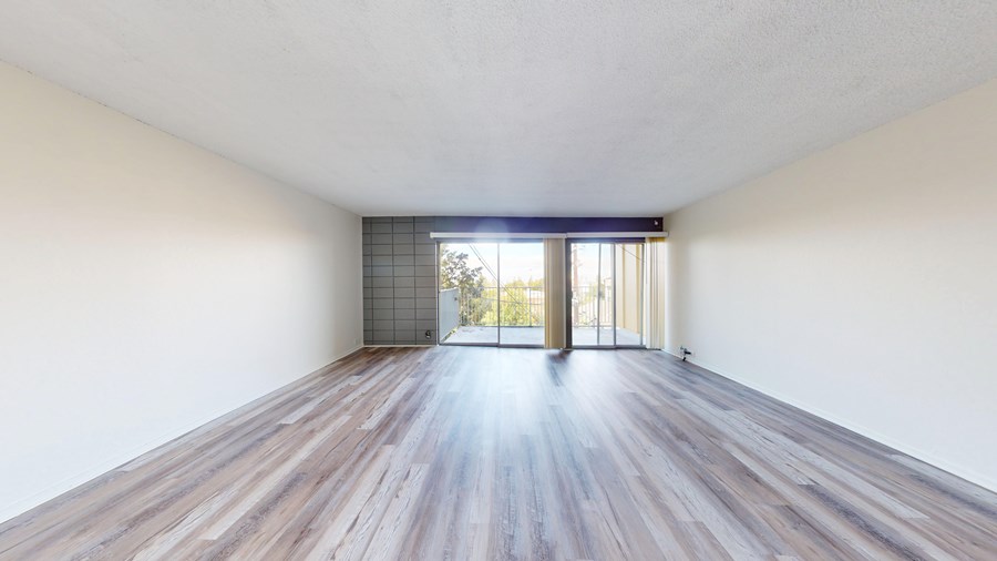 A room with wooden floors and a sliding glass door.