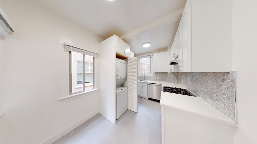 A white kitchen with a window and a countertop.