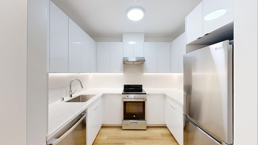 A modern kitchen with white cabinets and stainless steel appliances.